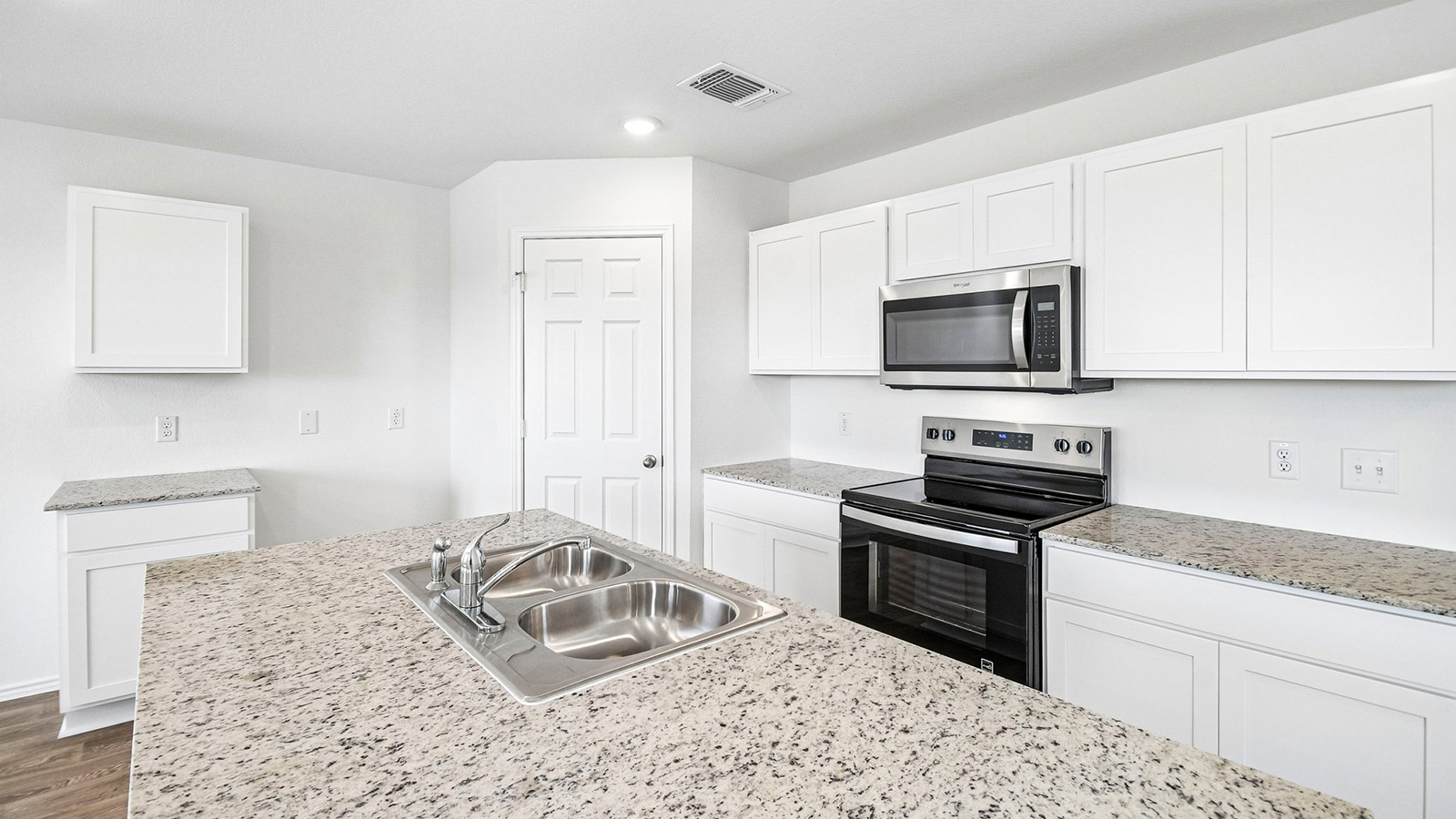 388 Old Stage Coach Road Jarrell, TX 76537 - Photo 4 of 30 Granite countertops and clean white cabinetry anchor this spacious modern kitchen with a central island.