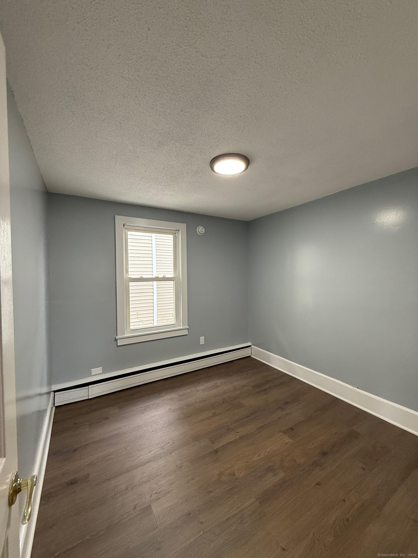79 Spring Street, Unit 2 Middletown, CT 06457 - Photo 12 of 15 an empty room with wooden floor and windows
