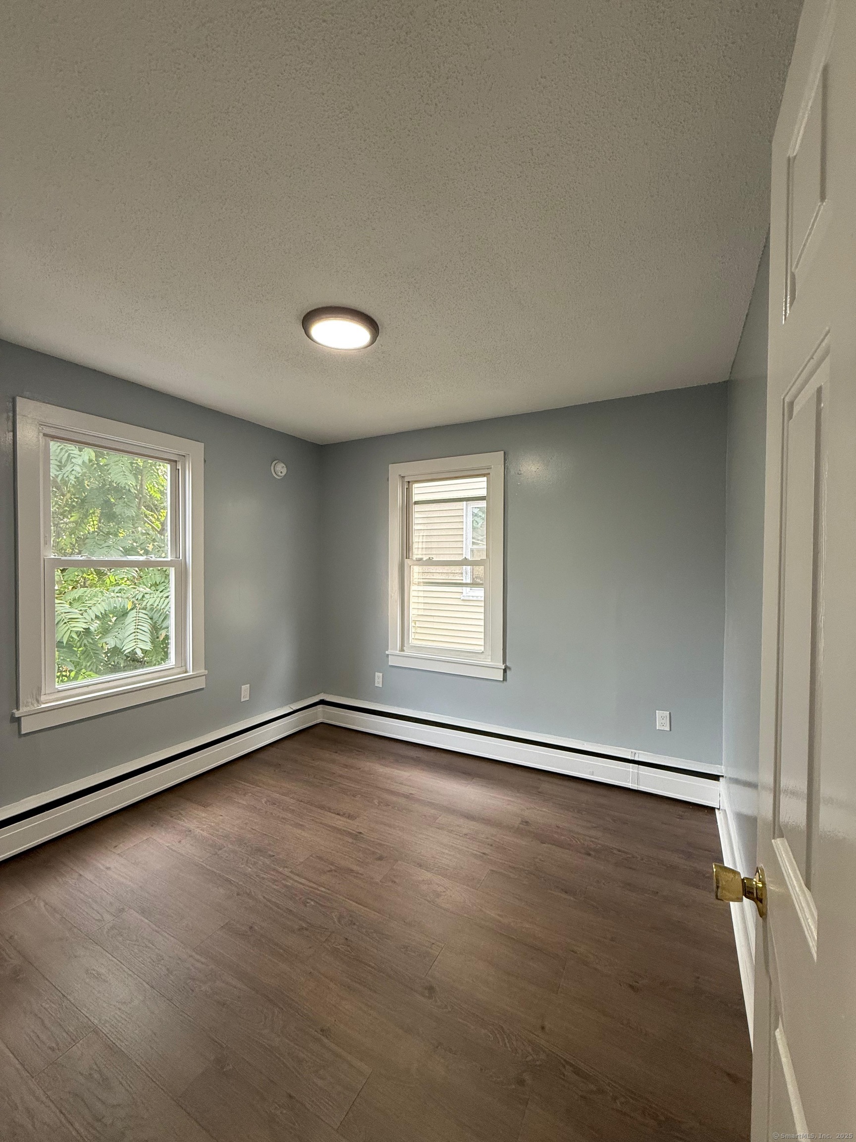 79 Spring Street, Unit 2 Middletown, CT 06457 - Photo 14 of 15 an empty room with wooden floor and windows