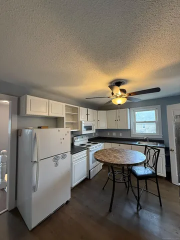 a kitchen with a table chairs and refrigerator