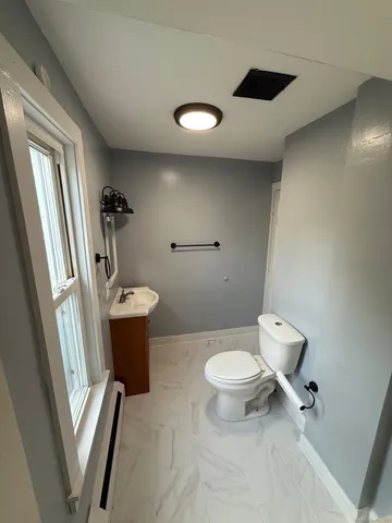 a bathroom with a toilet sink and mirror