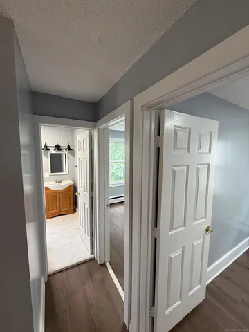 a view of empty room with window and wooden floor
