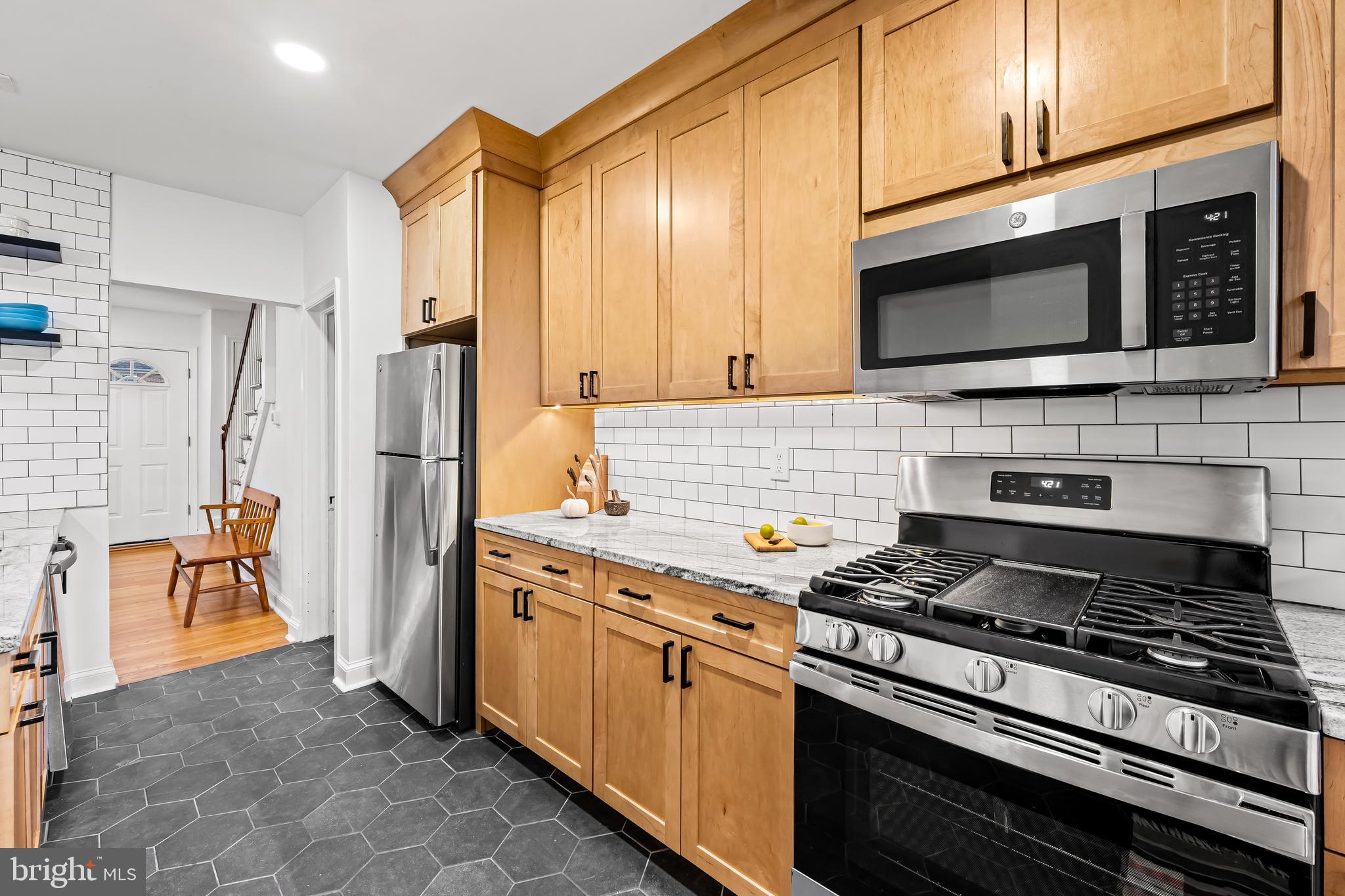 63 Burkshire Road Towson, MD 21286 - Photo 12 of 43 a kitchen with stainless steel appliances a stove a microwave and wood cabinets
