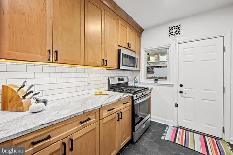 a kitchen with stainless steel appliances granite countertop a sink stove and cabinets