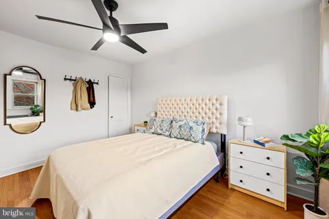 a bedroom with a bed a dresser and potted plants on the dresser