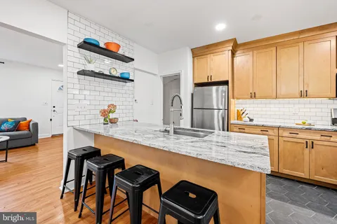 a kitchen with granite countertop a stove a sink and a refrigerator