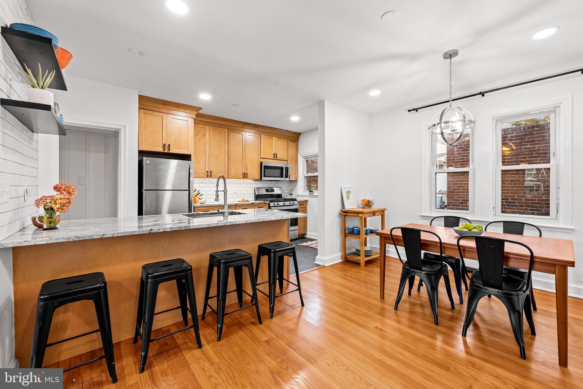 63 Burkshire Road Towson, MD 21286 - Photo 10 of 43 a dining hall with stainless steel appliances granite countertop a dining table and chairs with wooden floor