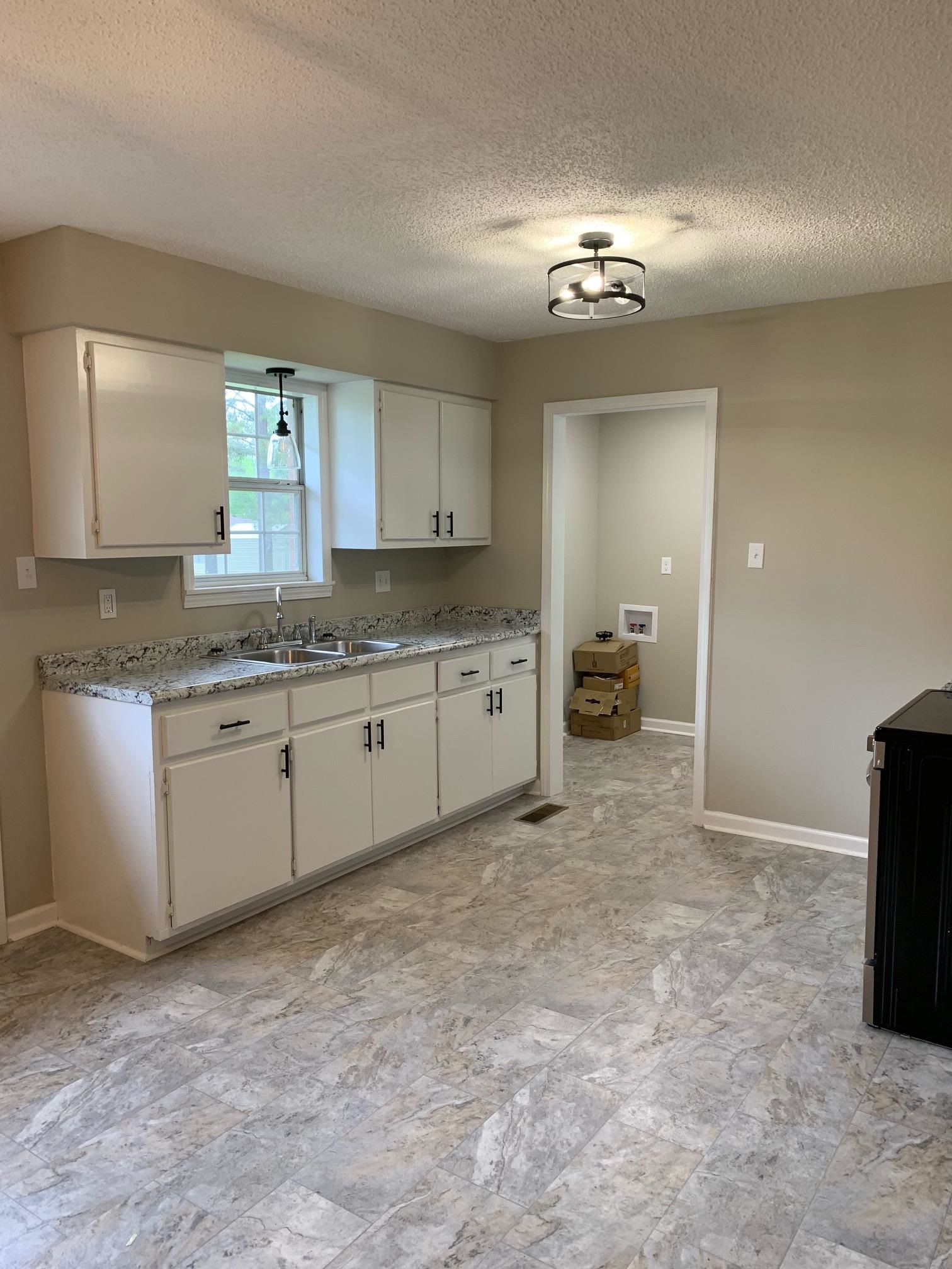 80 Halliburton Street Gates, TN 38037 - Photo 13 of 14 a spacious bathroom with a granite countertop sink a light fixture and a mirror