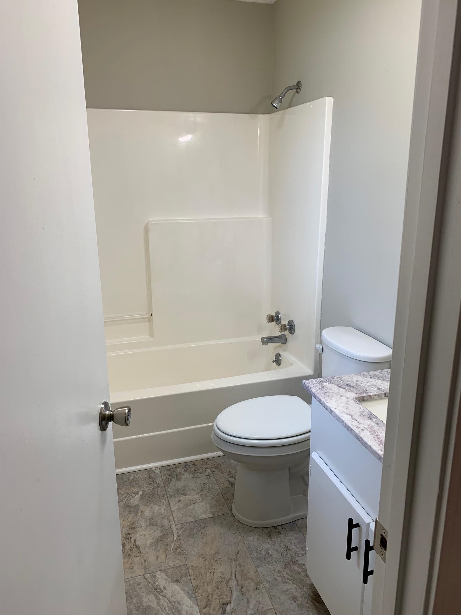 80 Halliburton Street Gates, TN 38037 - Photo 5 of 14 a bathroom with a granite countertop toilet a sink and bathtub