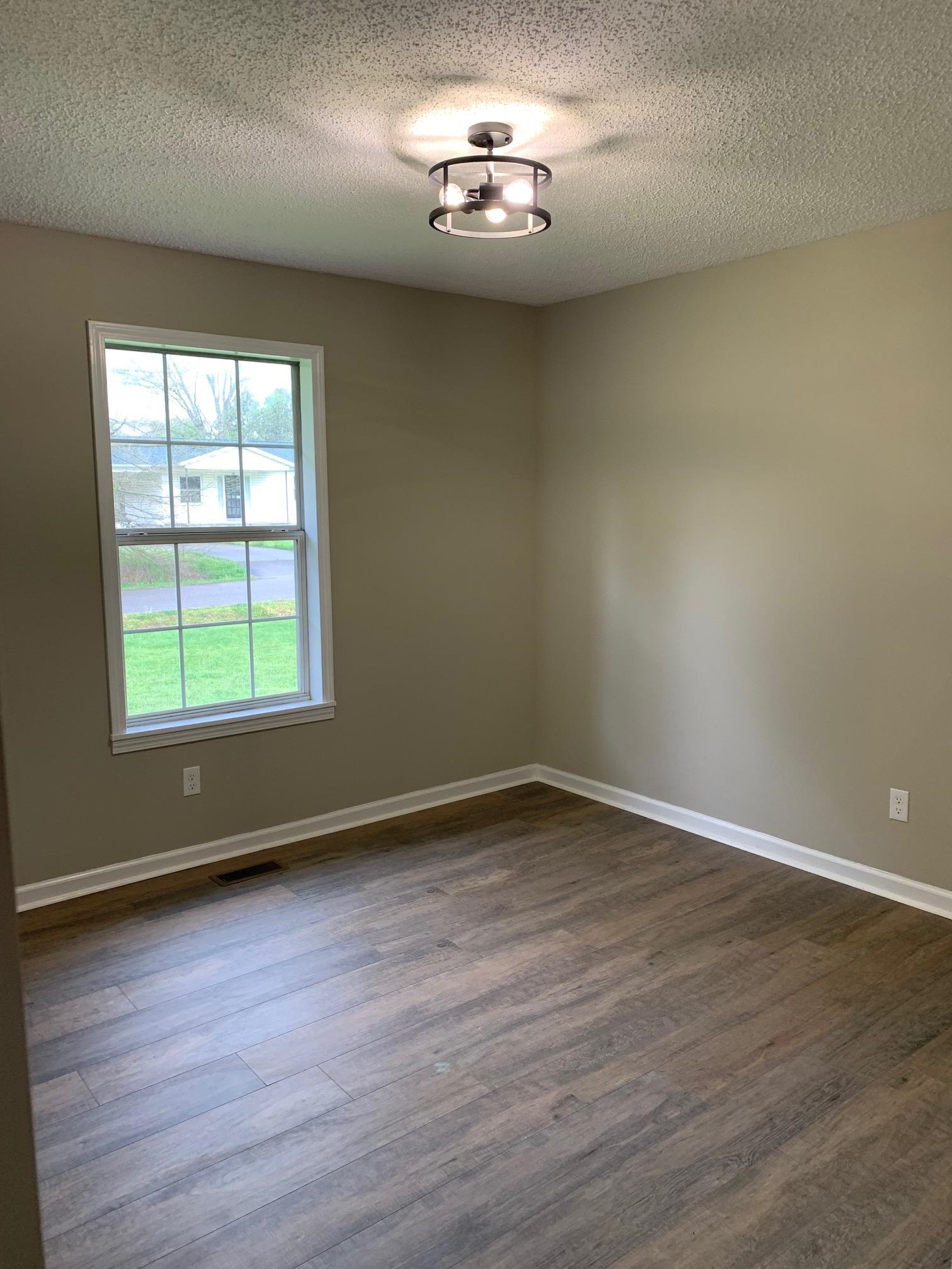 80 Halliburton Street Gates, TN 38037 - Photo 7 of 14 an empty room with wooden floor and windows