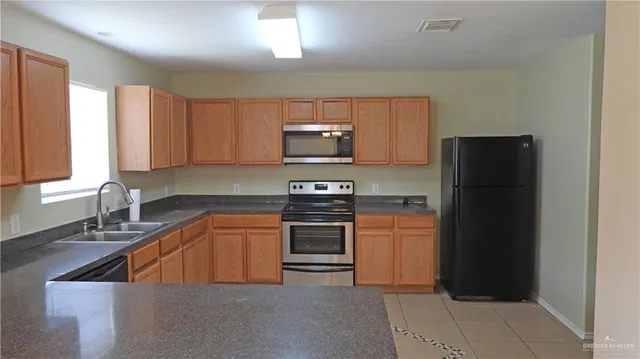 a kitchen with granite countertop a refrigerator and a sink