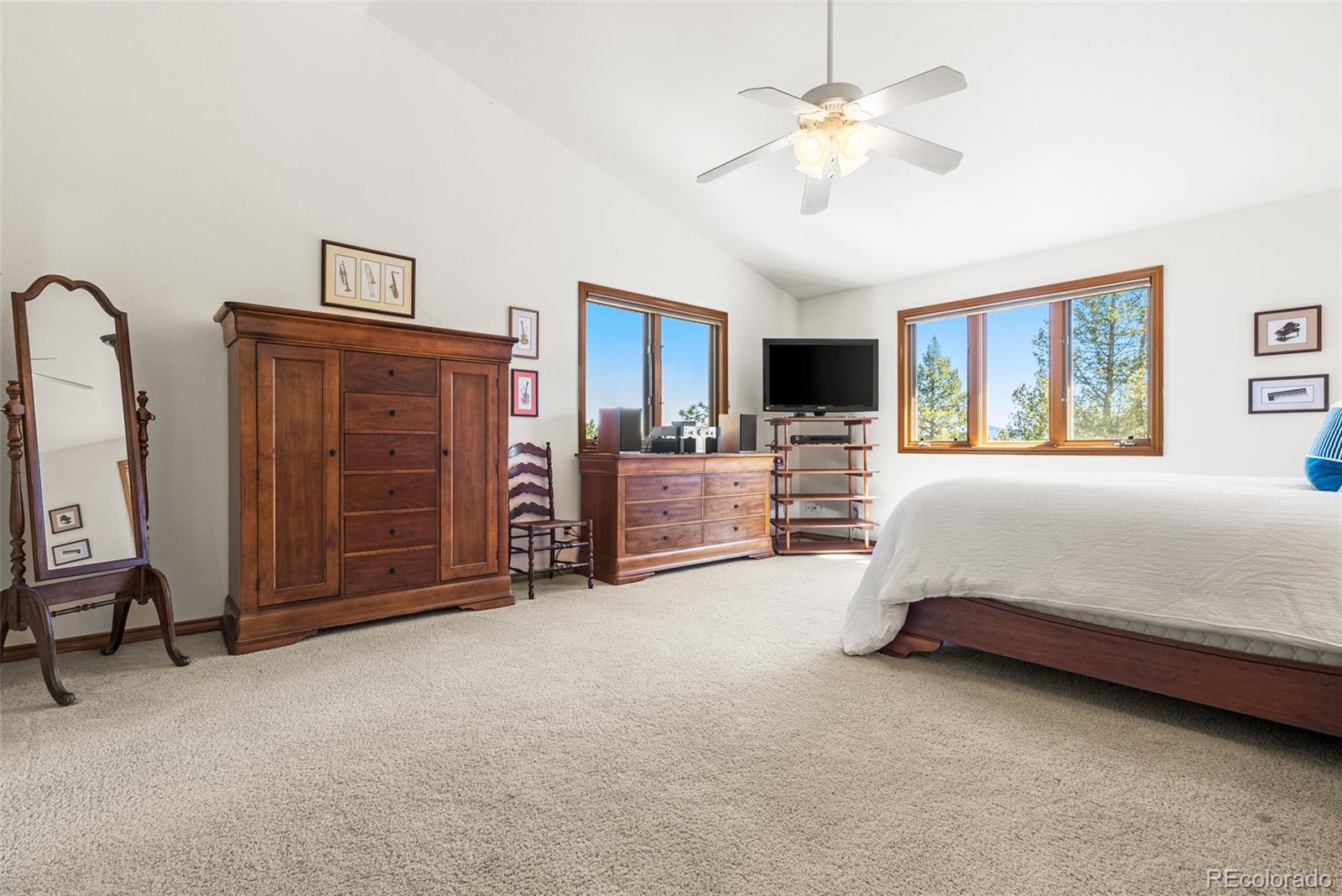 6252 King Drive Evergreen, CO 80439 - Photo 21 of 50 a spacious bedroom with a bed dresser and a chandelier
