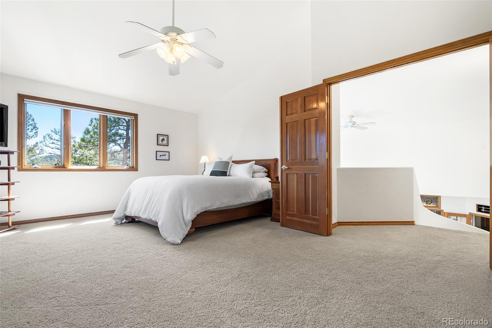 6252 King Drive Evergreen, CO 80439 - Photo 22 of 50 a bedroom with a bed dresser and a large window