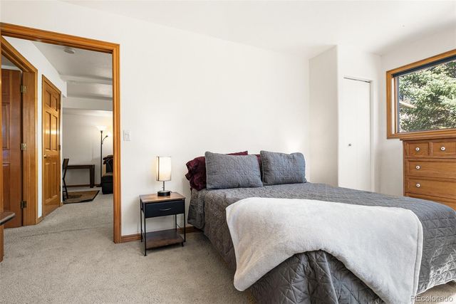 a bedroom with a bed and a dresser next to a window