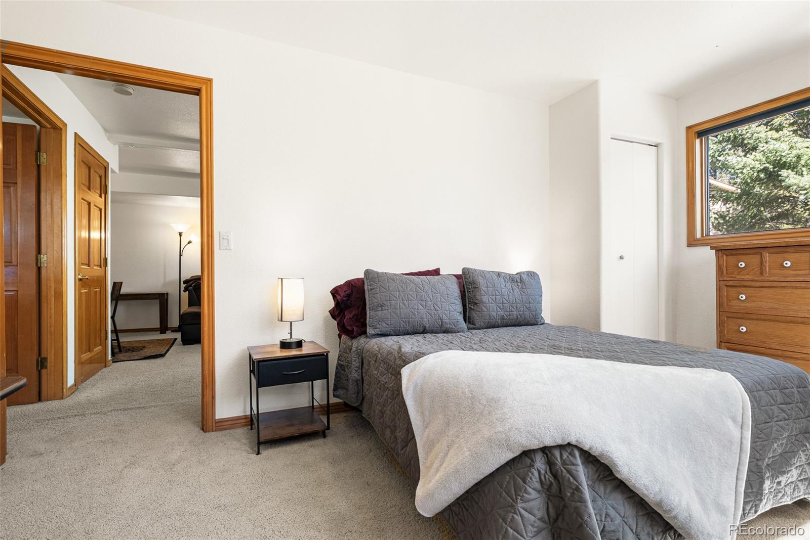 6252 King Drive Evergreen, CO 80439 - Photo 29 of 50 a bedroom with a bed and a dresser next to a window