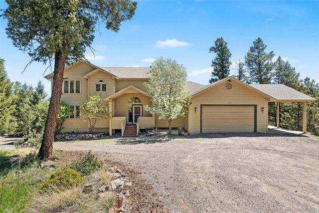 an aerial view of a house with swimming pool and large trees