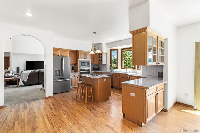 a kitchen with a sink a counter top space and stainless steel appliances