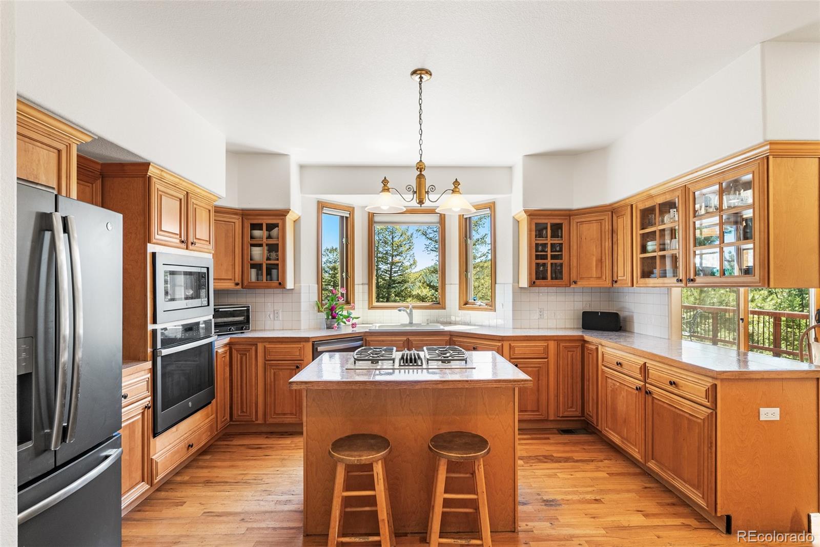 6252 King Drive Evergreen, CO 80439 - Photo 9 of 50 a kitchen with stainless steel appliances granite countertop a refrigerator a sink dishwasher a stove and a dining table with wooden floor