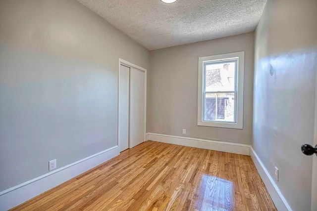 a view of a room with wooden floor and window