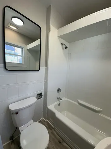 a white toilet sitting next to a bathtub