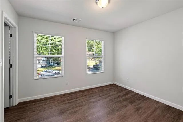 an empty room with wooden floor & closet area