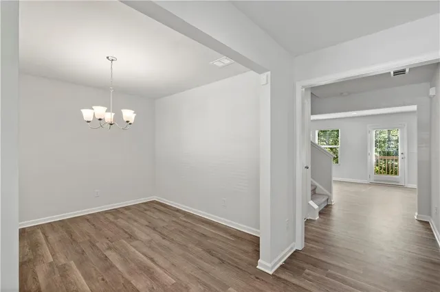 a view of a room with wooden floor and chandelier