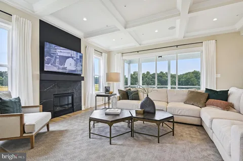 a living room with furniture fireplace and large windows