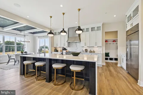 a kitchen with stainless steel appliances granite countertop a table chairs sink and wooden floor