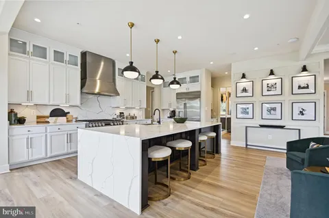 a kitchen with stainless steel appliances granite countertop a sink cabinets and wooden floor