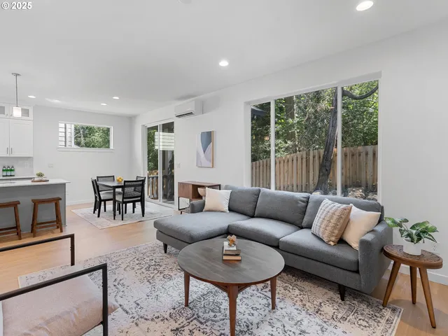 a living room with furniture and a dining table with kitchen view