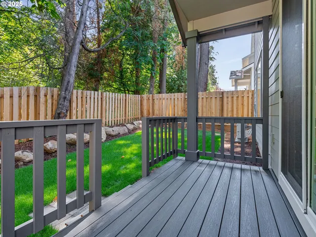 a view of a backyard with wooden fence and a bench