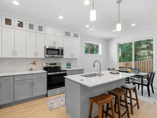 a kitchen with a stove a sink a dining table and chairs