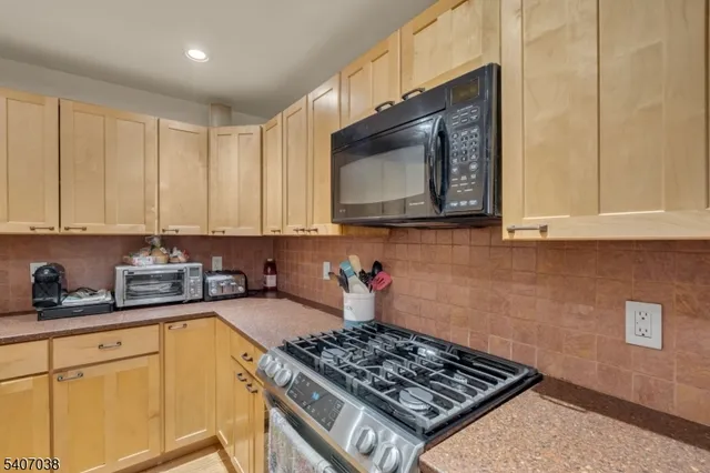 a kitchen with stainless steel appliances a stove a microwave sink and cabinets