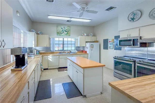 a kitchen with granite countertop a sink counter top space stainless steel appliances and cabinets