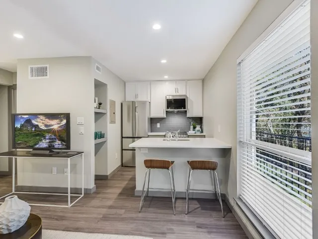 a kitchen with stainless steel appliances kitchen island granite countertop a refrigerator and microwave