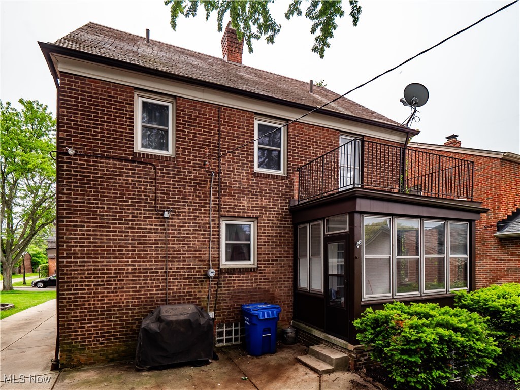 3845 Hillbrook Road Cleveland, OH 44118 - Photo 37 of 38 Rear view of property featuring a balcony, brick siding, a chimney, a sunroom, and entry steps