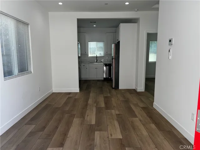 a view of a room with wooden floor and a bathroom