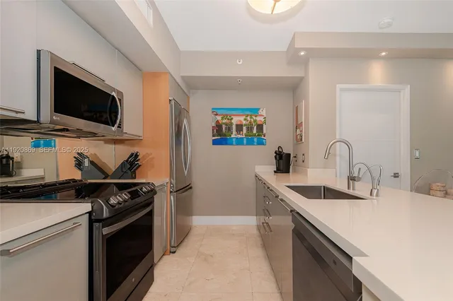 a open kitchen with stainless steel appliances a stove refrigerator sink and microwave