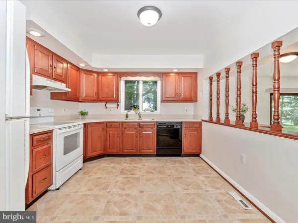 a large kitchen with stainless steel appliances granite countertop a stove a sink dishwasher and a refrigerator