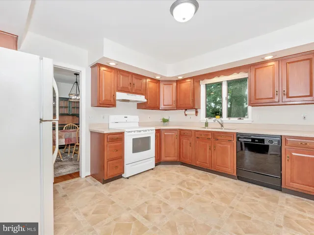 a kitchen with stainless steel appliances a stove top oven a sink a counter top space and cabinets