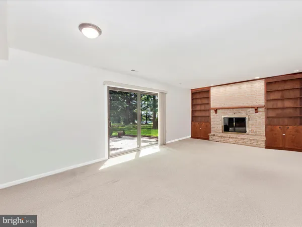 a view of a livingroom with a fireplace and a window