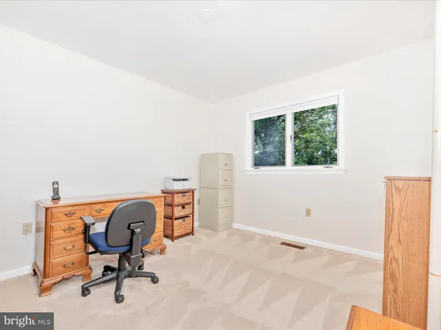a view of a workspace with furniture and a window