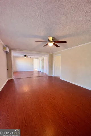 a view of empty room with wooden floor