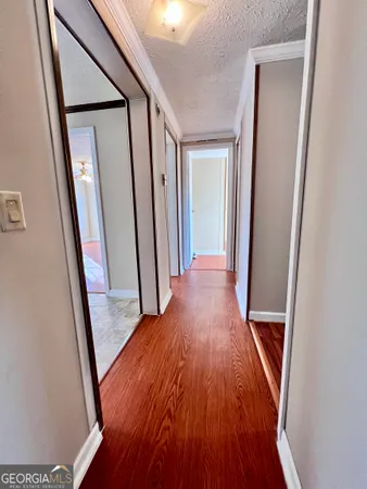 a view of a hallway with wooden floor