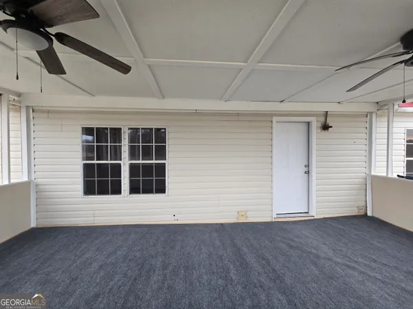 a view of an empty room with wooden floor and windows