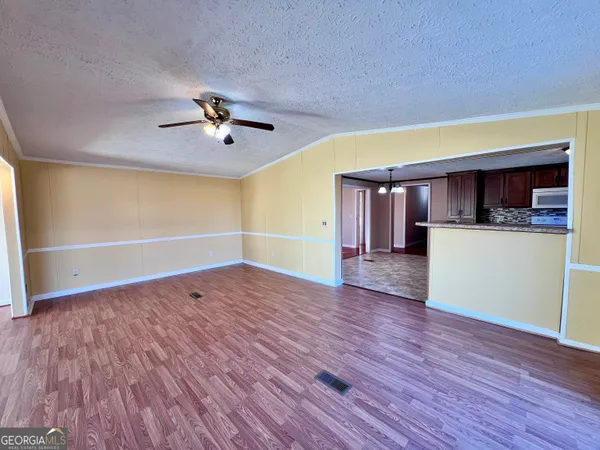 a view of a livingroom with wooden floor and a ceiling fan