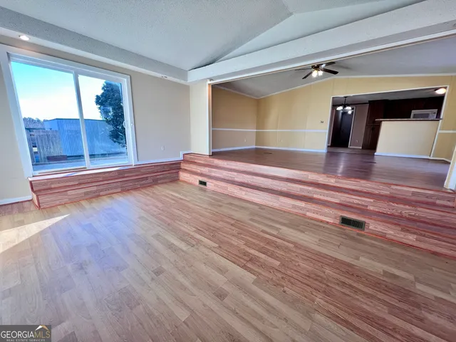 a view of room with wooden floor and fan