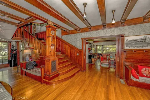 a living room with furniture a flat screen tv and floor to ceiling window