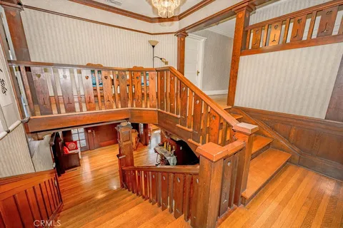 a view of a hallway with wooden floor and staircase