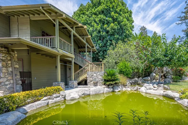 a front view of a house with a yard and potted plants
